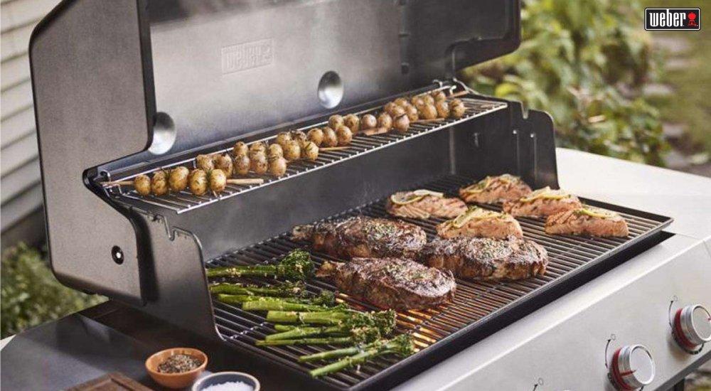grill with different meats and vegetables on it cooking